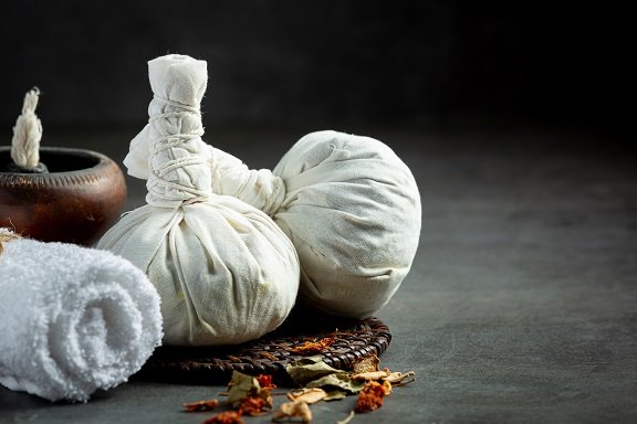 raditional herbal potli in Ayurvedic treatment session